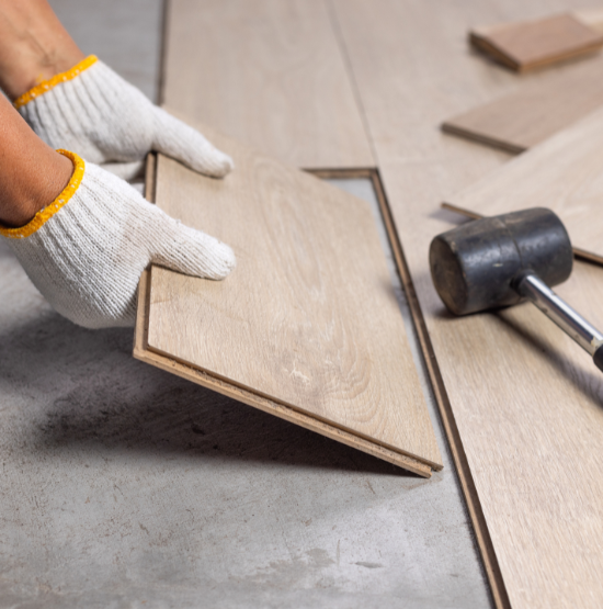Profesional instalando suelo de madera en vivienda